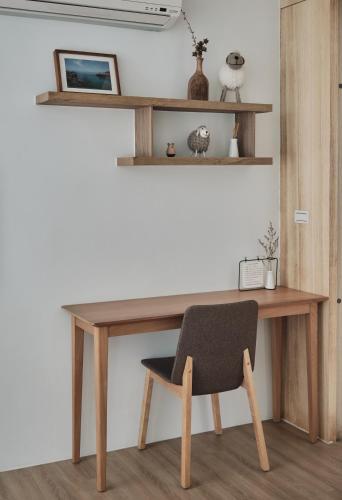 a wooden desk with a chair in a room at Here It's Home in Green Island