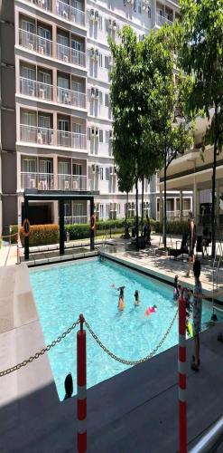 un groupe de personnes dans une piscine située dans un bâtiment dans l'établissement Trees Residences 2 Bedroom Unit T19 by HerGura PMS, à Manille