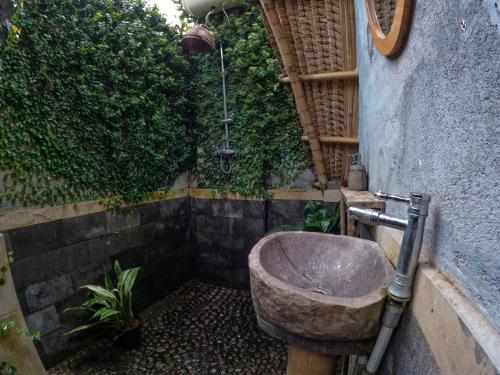 a bathroom with a stone sink next to a wall at Aranka Tempasan in Sangyang