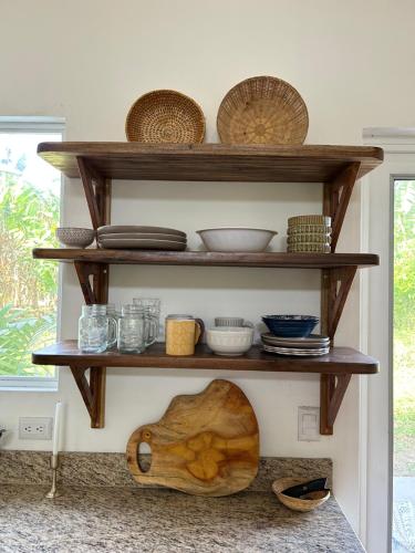 a shelf with bowls and other items on it at Casa Martin Cahuita Charming Spanish Home in Cahuita