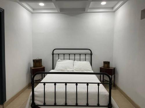 a black metal bed in a white room at Departamento Casa Blanca Paquimé in Nuevo Casas Grandes