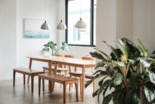 uma sala de jantar com mesa e cadeiras e uma planta em Here It's Home em Green Island