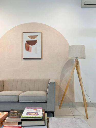 a living room with a couch and a table with books at Homely D'Sara @ Direct Link with MRT, Near Thomson Hospital & Sungai Buloh Hospital in Sungai Buluh