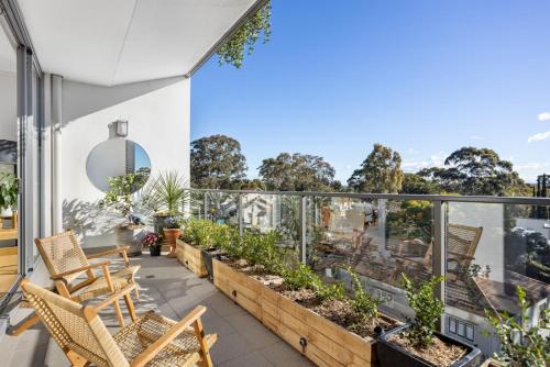 uma varanda com cadeiras e plantas num edifício em FINL503LC - Finlayson Heights em Sidney
