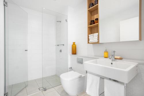 a white bathroom with a toilet and a sink at FINL503LC - Finlayson Heights in Sydney