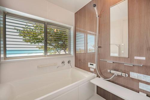 uma casa de banho com uma banheira e uma janela em VILLA KAWAZU - Umi - em Mitaka