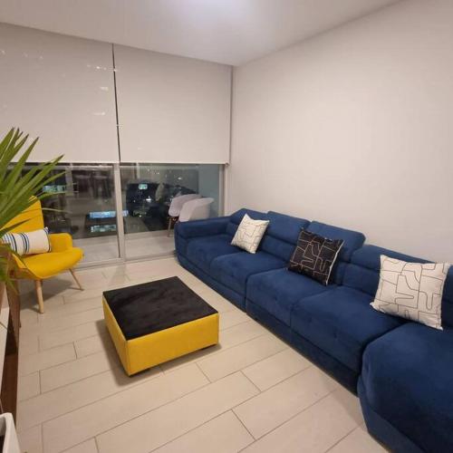 a living room with a blue couch and a yellow stool at Suite Martina 2 Personas Quito in Quito