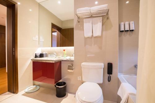 a bathroom with a toilet and a sink and a tub at Modena By Fraser New District Wuxi in Wuxi