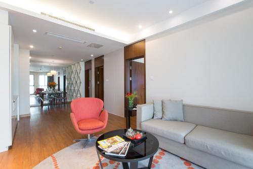 a living room with a couch and a red chair at Modena By Fraser New District Wuxi in Wuxi