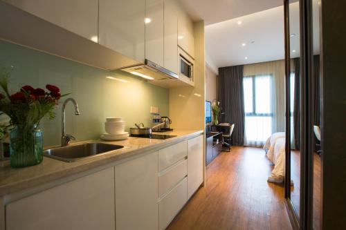 a kitchen with a sink and a bed in a room at Modena By Fraser New District Wuxi in Wuxi