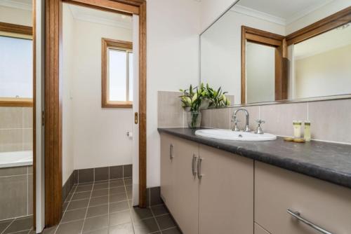 a bathroom with a sink and a mirror at Reflections Grabine Lakeside - Holiday Park in Bigga