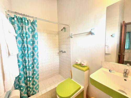 a bathroom with a green toilet and a shower at Summerset Residence Negril in Negril