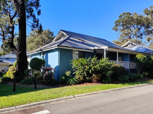 a blue house with solar panels on the roof at Blue Lago at Raffertys Resort in Cams Wharf