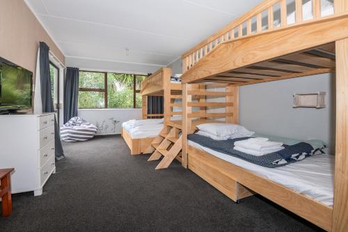 a bedroom with two bunk beds and a tv at As You Do in Rotorua