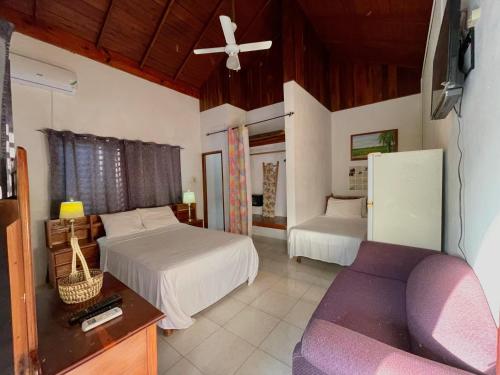 a bedroom with two beds and a couch at Summerset Residence Negril in Negril