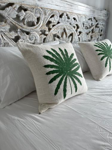 a bed with white pillows with a hempidered pineapple pillow at Bohemian Bali style in Hua Hin