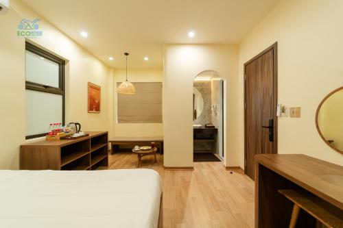 a bedroom with a bed and a vanity and a mirror at CAO BANG ECO HOUSE in Cao Bằng
