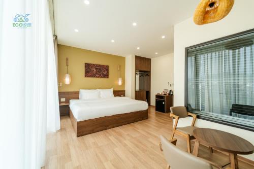 a hotel room with a bed and a table and chairs at CAO BANG ECO HOUSE in Cao Bằng
