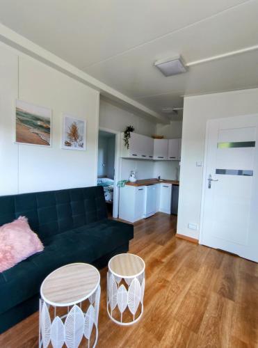 a living room with a black couch and two tables at Żurawi Staw- siedlisko obok Augustowa in Augustów