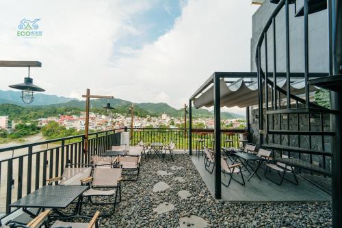 eine Terrasse mit Tischen und Stühlen auf dem Balkon in der Unterkunft CAO BANG ECO HOUSE in Cao Bằng