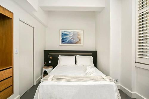 a bedroom with a large bed with white sheets at CLDN4- Studio in Central Sydney CBD with Pool in Sydney