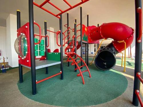 a play room with a playground with red equipment at NELI HOMESTAY @LADANG TANJUNG TERENGGANU in Kuala Terengganu