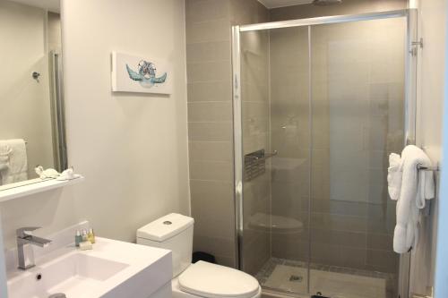 a bathroom with a shower and a toilet and a sink at Azure 515 Aruba Vacation Sunset Breeze in Palm-Eagle Beach