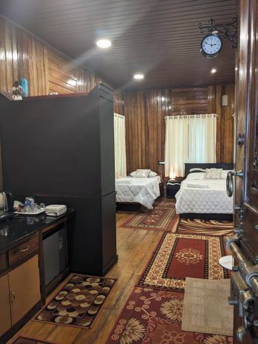 a room with two beds and a kitchen and a room with two beds at K V Wooden Homestay in Varkala