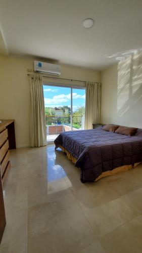 a bedroom with a large bed and a large window at Duplex solar in Federación