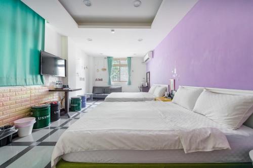 a large bedroom with two beds and a tv at Ju jiu House in Jiufen
