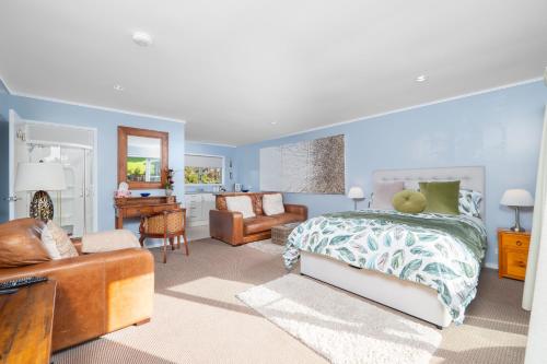 a bedroom with a bed and a living room at Pukeko Nest in Russell