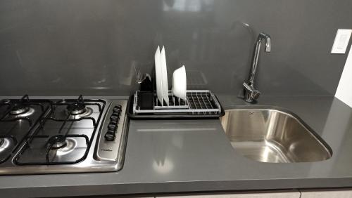 encimera de cocina con fregadero y fogones en Departamento nuevo en Centro Cuauhtémoc, en Monterrey