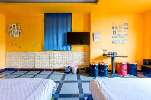 a hotel room with two beds and a flat screen tv at Ju jiu House in Jiufen