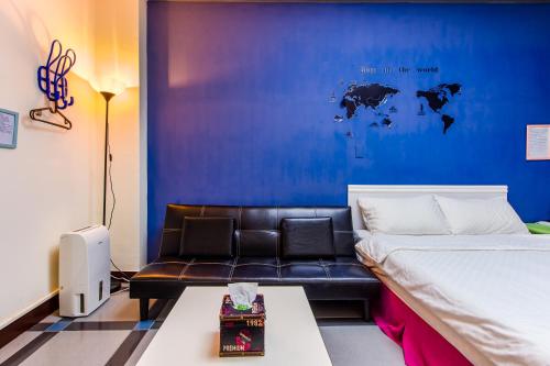 a bedroom with a couch and a blue wall at Ju jiu House in Jiufen