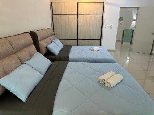 a large bed with two towels on top of it at 2 Storey, Hijayu 3D Alconix, Sendayan, Seremban in Seremban
