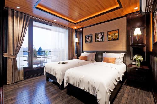 Arcady Boutique Cruise في ها لونغ: غرفة نوم بسريرين ونافذة كبيرة