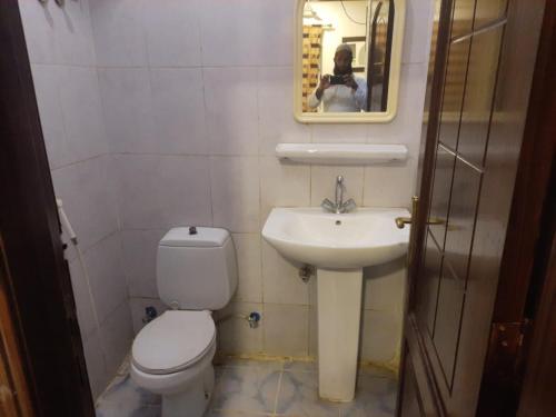 a bathroom with a toilet and a sink and a mirror at Bestex Group of Hotels in Makkah