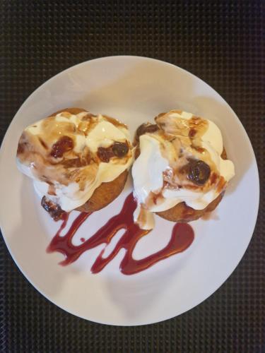 zwei Gebäckstücke auf einem weißen Teller mit Sirup in der Unterkunft Poarta Zaganului Cheia in Cheia