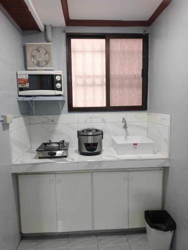 a kitchen with a sink and a microwave at Fabuluz Luxury at Princess Place in Malolos