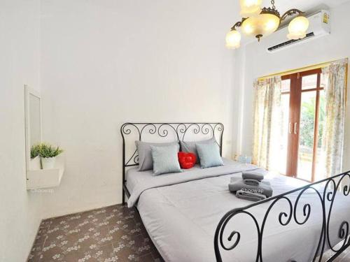 a bedroom with a large bed with red pillows at Sidewalk Boutique Hotel in Ko Samed