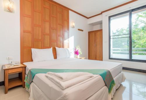 Schlafzimmer mit einem großen weißen Bett und einem Fenster in der Unterkunft New Siam III Guest House in Bangkok