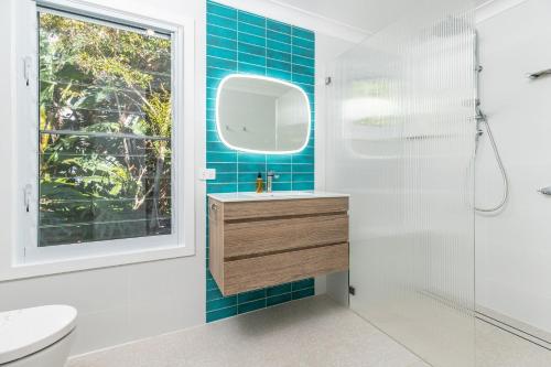 a bathroom with a sink and a shower and a mirror at Spinnaker 2 in Boomerang Beach