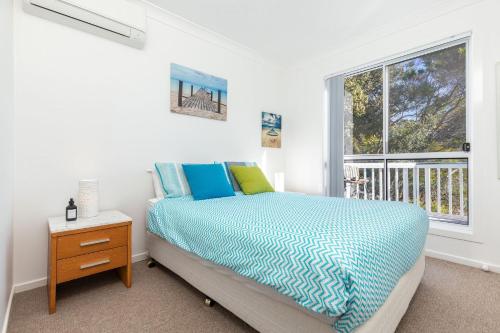a bedroom with a bed and a window at Spinnaker 2 in Boomerang Beach