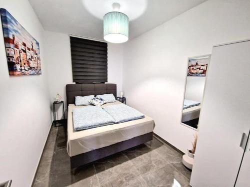 sypialnia z łóżkiem w białym pokoju w obiekcie Apartments Tadic w mieście Omišalj
