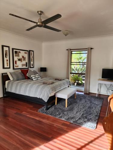 um quarto com uma cama e uma ventoinha de tecto em Brom Cottage em Mooloolah