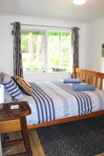 a bedroom with a large bed with a window at Willows Cottage in Warburton