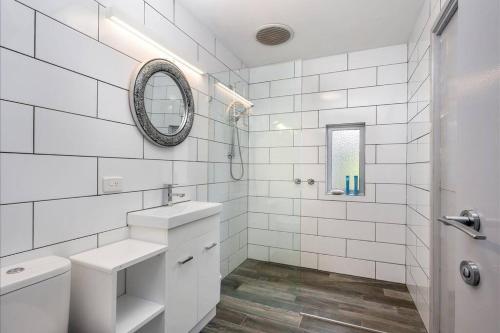 W białej łazience znajduje się umywalka i lustro. w obiekcie Sub-Zero Mt Hotham w mieście Mount Hotham