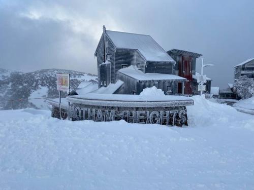 a house covered in snow next to a building at Sub-Zero Mt Hotham in Mount Hotham