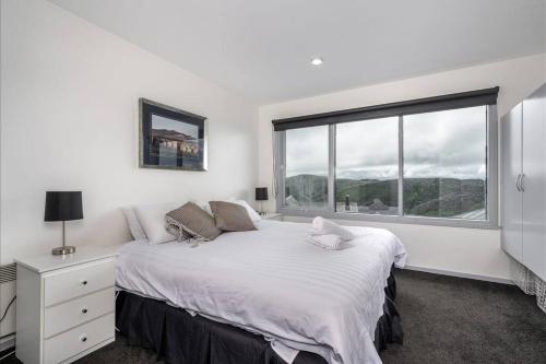 biała sypialnia z dużym łóżkiem i oknem w obiekcie Sub-Zero Mt Hotham w mieście Mount Hotham