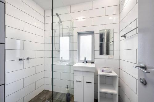 a white bathroom with a sink and a shower at Sub-Zero Mt Hotham in Mount Hotham